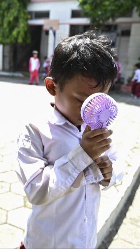 Tak hanya itu, pihak sekolah juga mengizinkan para siswa untuk membawa kipas angin portabel untuk menyegarkan tubuhnya. Foto: Chaideer Mahyuddin/AFP