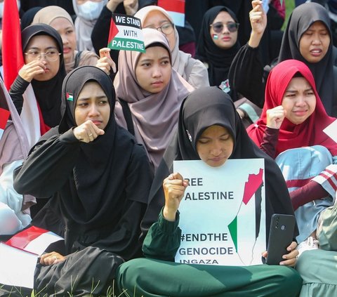 Beberapa mahasiswa terlihat menangis saat menunjukkan poster saat aksi Solidaritas Palestina digelar sambil melantunkan tuntutannya yang menggambarkan kepedulian mereka terhadap nasib warga Palestina di Gaza. Foto: merdeka.com / Arie Basuki