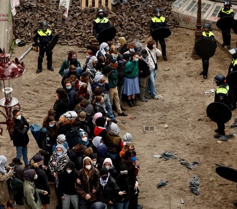 Namun, kepolisian anti huru-hara mampu merobohkan barikade yang dibuat pengunjuk rasa dan berhasil memukul mereka dengan tongkat dan sekop. Foto: REUTERS / Piroschka van de Wouw<br>