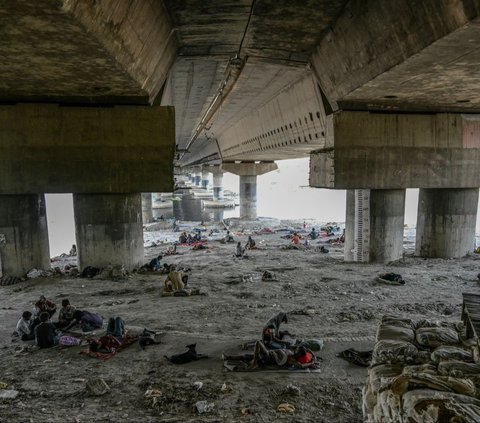 Sejumlah warga beristirahat di bawah kolong sebuah jembatan di dekat Sungai Yamuna, ketika gelombang panas melanda, di New Delhi, India, pada 31 Mei 2024. Kenaikan suhu ekstrem saat gelombang panas menghantam India telah merenggut banyak korban jiwa. Foto: AFP