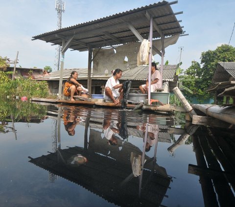 Sejumlah warga mencuci pakaian di terusan Sungai Kalimalang di Desa Karangasih, Kecamatan Cikarang Utara, Kabupaten Bekasi, Jawa Barat, pada Rabu (12/6/2024). Krisis ketersediaan air bersih menyebabkan warga Desa Karangasih kesulitan untuk memenuhi kebutuhan sehari-hari, seperti memasak, mandi, hingga mencuci baju. Foto: Merdeka.com/<br>Imam Buhori