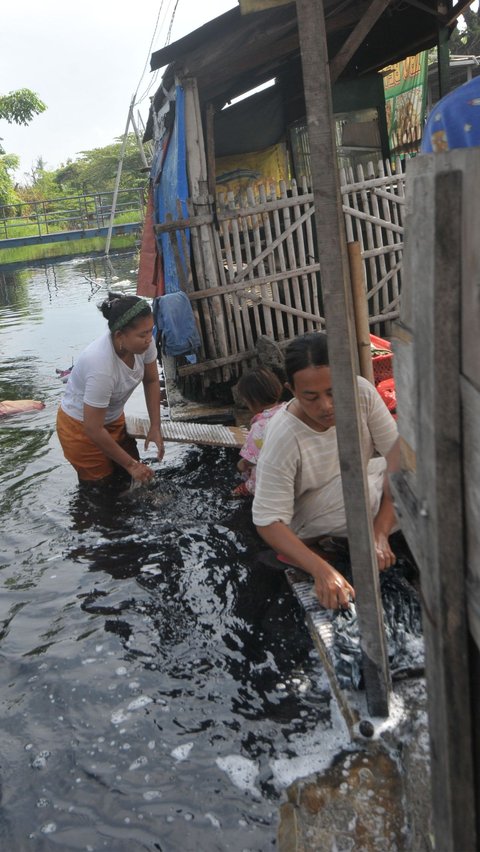 Sebagian warga pun terpaksa mencuci baju dengan memanfaatkan terusan Kalimalang yang airnya menghitam dan bau karena limbah. Foto: Merdeka.com/<br>Imam Buhori