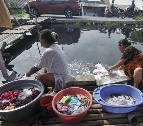 FOTO: Dilanda Krisis Air Bersih, Warga Bekasi Terpaksa Cuci Baju di Terusan Kalimalang yang Bau