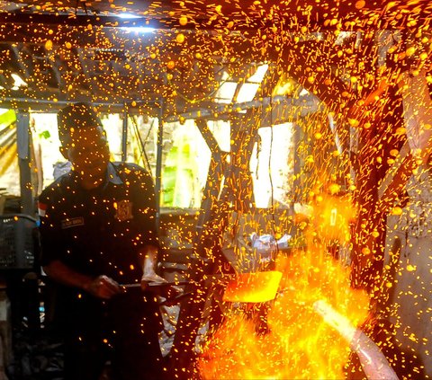 Seorang perajin membuat pisau khusus sembelih hewan kurban di Bengkel Tempa dan Asah Bilah HM, Jalan Akasia, Pamulang Timur, Tangerang selatan, Kamis (13/6/2024).  Bengkel tempa di bawah naungan Juru Sembelih Halal (Juleha) ini dalam setiap bulan mampu meproduksi 40 beragam jenis pisau sembelih. Merdeka.com/Arie Basuki<br>