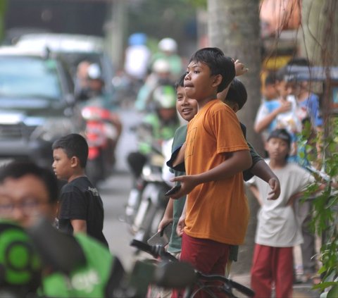 FOTO: Potret Anak-Anak Tetap Nekat Berburu Klakson Telolet Bus Meski Mengancam Nyawa