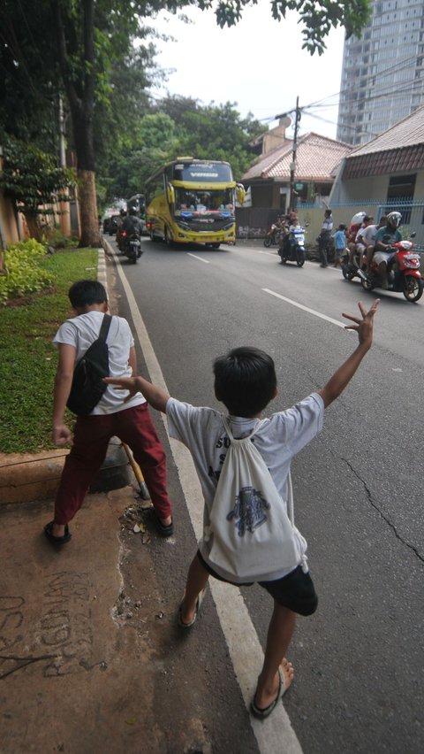 FOTO: Potret Anak-Anak Tetap Nekat Berburu Klakson Telolet Bus Meski Mengancam Nyawa