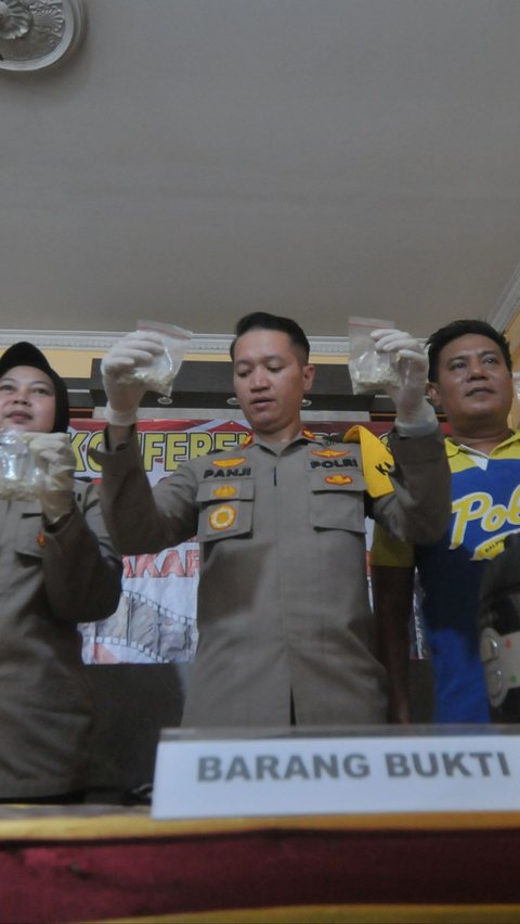 Kapolsek Cakung Kompol Panji Ali Chandra didampingi jajarannya menunjukkan barang bukti ratusan butir pil ekstasi yang diamankan dari tersangka PCR alias Adit dalam rilis kasus peredaran narkoba di Polsek Cakung, Jakarta, Jumat (14/6/2024). Merdeka.com/Imam Buhori