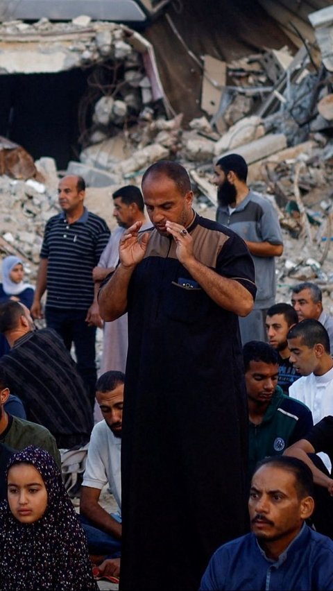 Di sana mereka berdoa untuk menemukan kedamaian dan kekuatan saat melaksanakan salat Iduladha yang diadakan apa adanya di tengah kehancuran. Foto: REUTERS / Mohammed Salem<br>