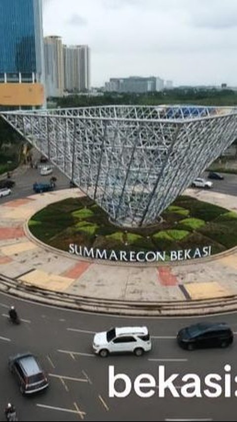 The Beautiful and Busy Summarecon Icon in Bekasi Becomes Like a Stone Monument in the Middle of a Grass Field, with Vehicles Passing by