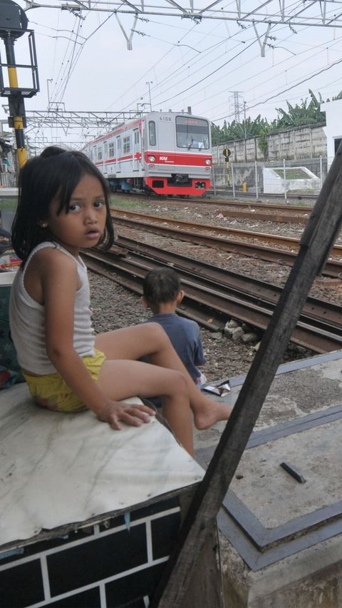 Seorang warga yang tinggal di pinggir rel tersebut menyempatkan untuk bercerita sedikit selama tinggal di sana. Foto: merdeka.com / Imam Buhori<br>