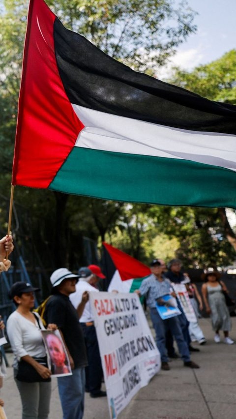 Bendara Palestina yang dibawa massa demonstran berkibar selama aksi protes. Foto: Reuters