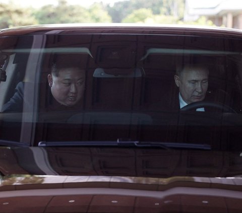 Sementara Kim Jong-un duduk di kursi penumpang di sebelah Putin. <br><br>Kemudian mobil yang dikemudikan oleh Putin berjalan melewati tempat yang terlihat seperti taman. Foto: Sputnik/Gavriil Grigorov/Pool via REUTERS<br>