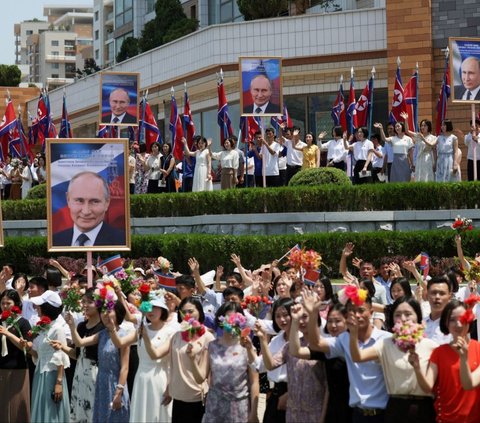 Warga Korea Utara terlihat tumpah di pinggir jalan saat menyambut kedatangan Presiden Rusia Vladimir Putin untuk bertemu dengan pemimpin Korea Utara, Kim Jong-un. Foto: Sputnik/Gavriil Grigorov/Pool via REUTERS<br>