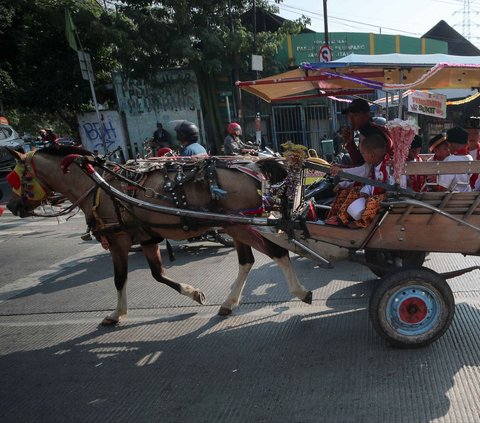 Sejumlah penganten sunat menaiki delman selama arak-arakan dari Markas Palang Merah Indonesia (PMI) Jakarta Utara, Jumat (21/6/2024). Dalam ranka memperingati HUT ke-497 Kota Jakarta, Palang Merah Indonesia (PMI) dan Pemerintah Kota Administrasi Jakarta Utara, mengadakan arak-arakan penganten sunat menggunakan 11 delman. Foto: Liputan6.com/Herman Zakharia