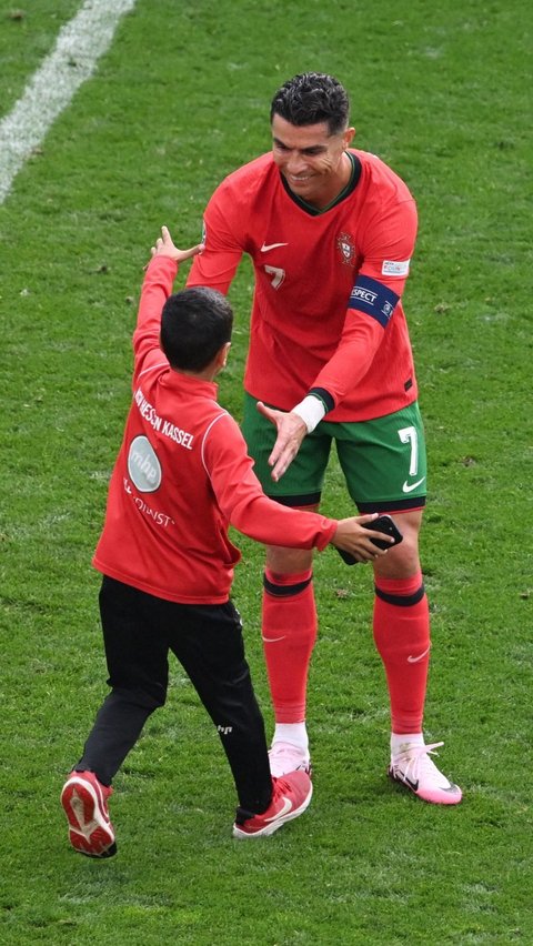 Namun untuk penyusup yang satu ini tampak mendapatkan sambutan yang hangat dari Cristiano Ronaldo. Foto: Reuters<br>