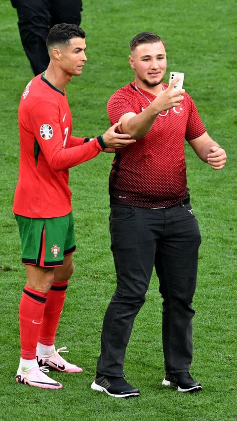 Aksi suporter yang menyusup lapangan saat berfoto selfie dengan pemain Portugal Cristiano Ronaldo selama pertandingan. Foto: Reuters