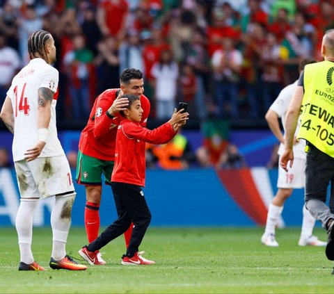 Aksi suporter cilik ketika mendapat rangkulan hangat oleh Ronaldo yang mau dengan sukarela berfoto dengannya. Foto: Reuters<br>