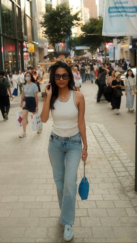 Azizah menikmati Myeongdong dengan tampilan kasual berupa tank top warna putih dan celana jeans.