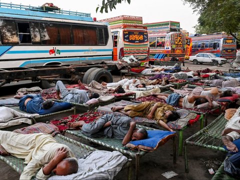 FOTO: Di Tengah Gelombang Suhu Panas Ekstrem, Sopir Bus di Pakistan Ini Justru Tidur Nyenyak di Luar Ruangan