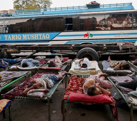 FOTO: Di Tengah Gelombang Suhu Panas Ekstrem, Sopir Bus di Pakistan Ini Justru Tidur Nyenyak di Luar Ruangan