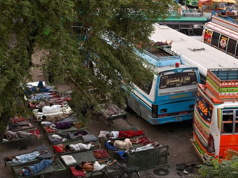 FOTO: Di Tengah Gelombang Suhu Panas Ekstrem, Sopir Bus di Pakistan Ini Justru Tidur Nyenyak di Luar Ruangan