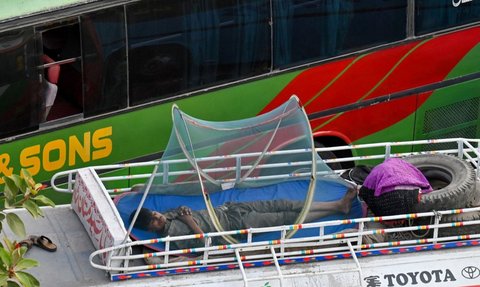 FOTO: Di Tengah Gelombang Suhu Panas Ekstrem, Sopir Bus di Pakistan Ini Justru Tidur Nyenyak di Luar Ruangan