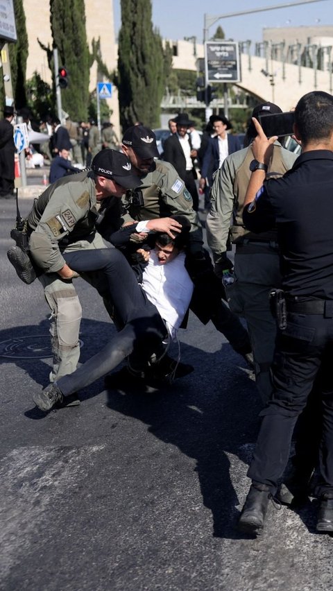 Selain itu, para demonstran Yahudi ultra-Ortodoks juga melakukan aksi memblokir jalan di Yerusalem. Foto: REUTERS / Ronen Zvulun<br>