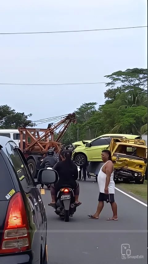 Kuli bangunan tetap fokus bekerja meskipun terjadi kecelakaan mobil di depan mereka