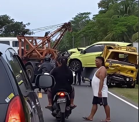 Kuli bangunan tetap fokus bekerja meskipun terjadi kecelakaan mobil di depan mereka.