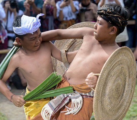 Anak-anak bertarung dalam tradisi Perang Pandan di Desa Tenganan, Karangasem, Bali, Rabu (5/6/2024). Tradisi Perang Pandan, yang juga dikenal sebagai Mekare-kare, merupakan bagian dari ritual Sasih Sembah di Desa Tenganan, Bali. Foto: Sonny Tumbelaka/AFP