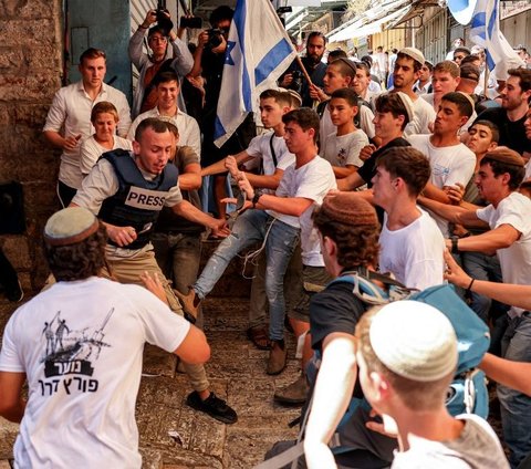 Massa ultranasionalis Israel melakukan pengeroyokan terhadap jurnalis lepas Palestina, Saif Kwasmi selama parade 'Hari Yerusalem' di sekitar kompleks Masjid Al Aqsa, Yerusalem, pada 5 Juni 2024. Aksi barbar warga Israel ini menyebabkan Saif Kwasmi terluka. Foto: Hazem Bader/AFP
