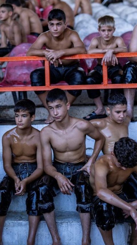 Tak hanya pria berotot besar saya yang berpartisipasi, gulat ini juga diikuti anak-anak remaja. Mereka terlihat tak mau kalah turut berlomba gulat minyak ini. Foto: Yasin AKGUL / AFP<br>