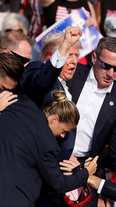 Donald Trump berpidato dengan perlindungan body guard setelah ditembak di Butler Farm Show, Butler, Pennsylvania, Amerika Serikat, pada Minggu (13/7) pagi WIB. Foto: REUTERS