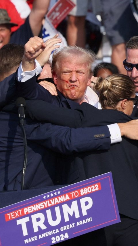 Ekspresi Donald Trump mengangkat tangannya ke hadapan para pendukung setelah ditembak saat kampanye di Butler Farm Show, Butler, Pennsylvania, Amerika Serikat, pada Minggu (13/7) pagi WIB. Foto: REUTERS