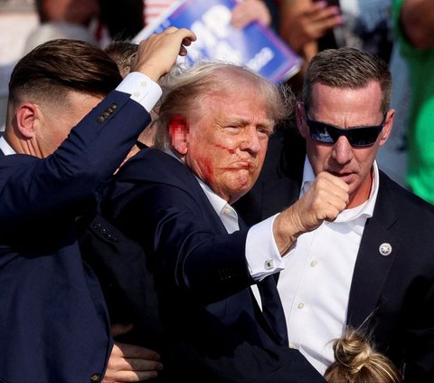 Mantan presiden Amerika Serikat yang juga kandidat presiden dari Partai Republik, Donald Trump terluka sesusai ditembak saat melakukan kampanye Pilpres Amerika Serikat di Butler Farm Show, Butler, Pennsylvania, Amerika Serikat, pada Minggu (13/7/2024) pagi WIB. Aksi penembakan yang diduga dilakukan penembak jitu atau sniper tersebut membuat Donald Trump mengalami luka. Foto: Reuters