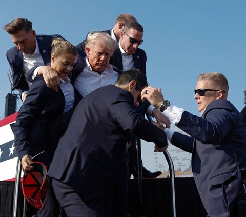 Mantan presiden Amerika Serikat yang juga kandidat presiden dari Partai Republik, Donald Trump ditembak saat melakukan kampanye Pilpres Amerika Serikat di Butler Farm Show, Butler, Pennsylvania, Amerika Serikat, pada Minggu (14/7/2024) pagi WIB. Pasukan Secret Service yang berada di lokasi pun langsung memperketat keamanan seusai insiden penembakan tersebut. Foto: AFP