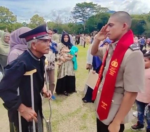 Ia kemudian memakaikan atribut yang dipake pada sang ayah dan mengambil sikap hormat pada ayahnya.