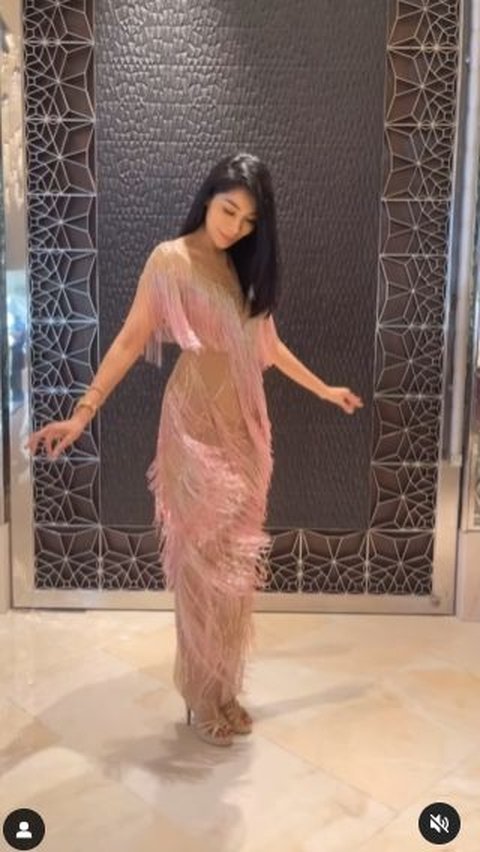 Lalu ia mengenakan  fringe gown pink yang cantik yang juga hasil rancangan desainer Indonesia, Anaz.