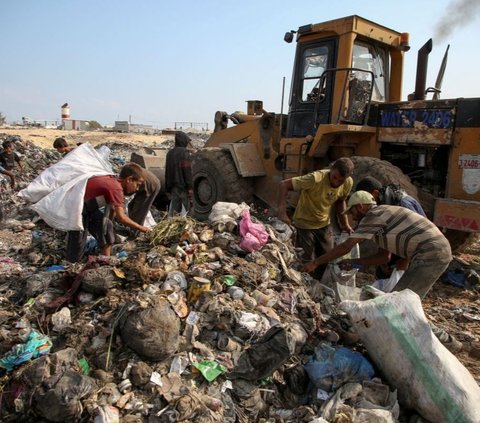 Para pemulung yang merupakan warga Palestina ini hidup dalam kondisi sulit.<br><br>Mereka berkumpul untuk mencari barang-barang yang dapat mereka gunakan atau dijual demi memenuhi kebutuhan sehari-hari. Foto: REUTERS / Hatem Khaled<br>