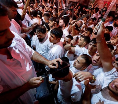 Di Irak, perayaan Asyura dipusatkan di Kota Karbala, tempat terjadinya pertempuran bersejarah tersebut. Festival di Karbala menarik ribuan pengunjung yang mengenakan pakaian serba hitam sebagai tanda berkabung. Foto: Reuters<br>