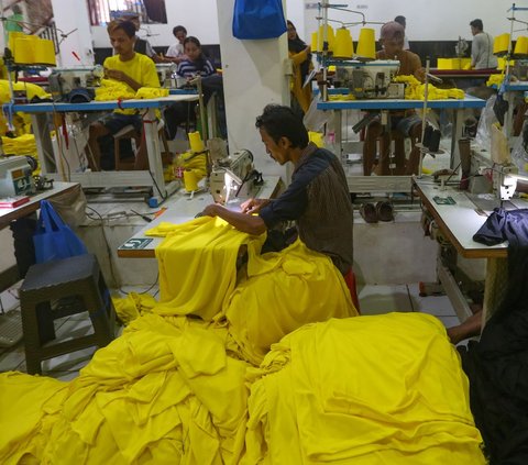 Sejumlah pekerja menjahit kain yang telah disablon saat menyelesaikan pesanan kaos di perusahaan konfeksi Sinergi Adv, kawasan Srengseng Sawah, Jakarta, Selasa (2/7/2024). Kenaikan nilai mata uang dolar Amerika Serikat (AS) terhadap Rupiah hingga minurunnya tingkat pesanan menyebabkan industri tekstil lesu. Merdeka.com/Arie Basuki