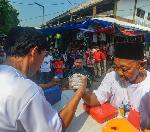 Peserta mengikuti perlombaan adu panco di Pasar Rakyat Ciseeng, Bogor, Sanbtu (20/07/2024). Lomba adu panco yang diikuti pedagang pasar ini diadakan dengan melibatkan Persatuan Olahraga Gulat Tangan Indonesia (POGTI) di bawah binaan Komite Olahraga Rekreasi Masyarakat Indonesia (KORMI) Kabupaten Bogor. Foto: Merdeka.com/Arie Basuki