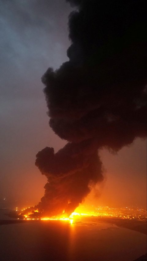 Asap hitam pekat terlihat dari kejauhan saat depot kilang minyak di pelabuhan tersebut terbakar hebat. Foto: Houthi Media Centre/Handout via REUTERS