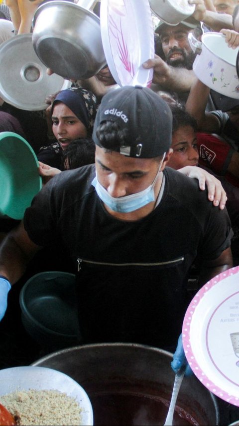 Anak-anak Palestina di Gaza menerima makanan dari dapur amal. Gempuran serangan udara Israel masih menghujani wilayah Gaza. Kondisi ini membuat nasib warga Palestina di Gaza semakin memprihatinkan.