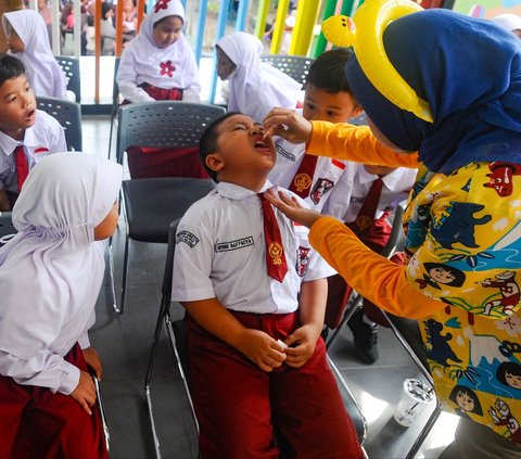 Murid kelas 1 SDN Srengseng Sawah 12 menerima vaksin polio selama kegiatan Pekan Imunisasi Nasional 2024 di Ruang Publik Terpadu Ramah Anak (RPTRA) Shibi, Srengseng Sawah, Jakarta Selatan, Selasa (23/7/2024). Hari ini, Kementerian Kesehatan Republik kembali menggelar Pekan Imunisasi Nasional (PIN) Polio. Foto: Merdeka.com/Arie Basuki