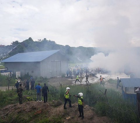 Tayangan televisi menunjukkan petugas pemadam kebakaran berusaha memadamkan api dan asap hitam tebal yang mengepul ke angkasa.