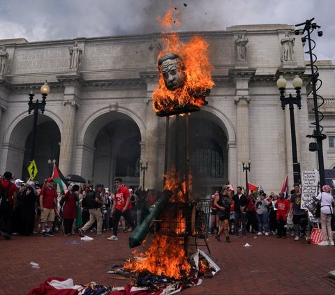 Api berkobar ketika pengunjuk rasa pro-Palestina membakar boneka PM Israel Benjamin Netanyahu di luar Union Station, dekat Gedung Capitol, Washington, Amerika Serikat, pada 24 Juli 2024. Pengunjuk rasa pro-Palestina memprotes kedatangan PM Israel Benjamin Netanyahu di Amerika Serikat untuk berpidato dalam Kongres AS. Foto: Reuters