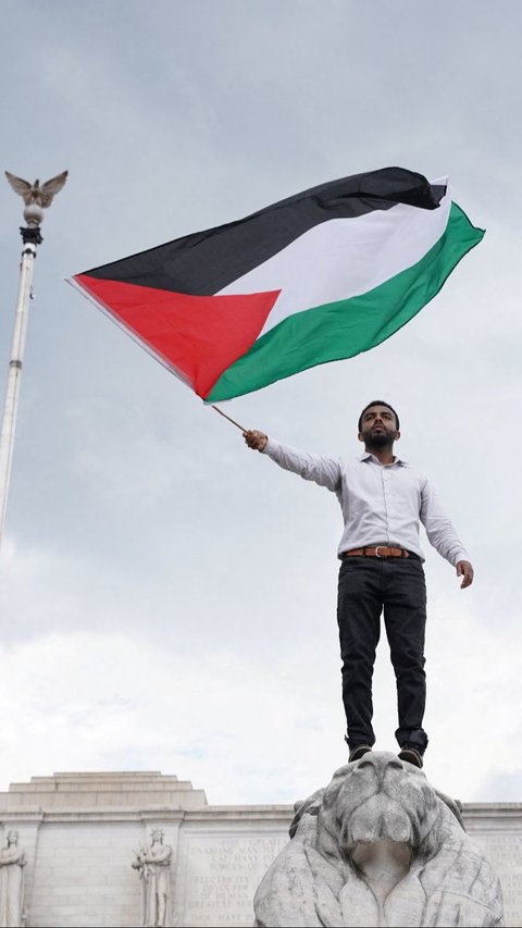 Sementara, pengunjuk rasa tampak mengibarkan bendera Palestina setinggi-tingginya. Foto: Reuters