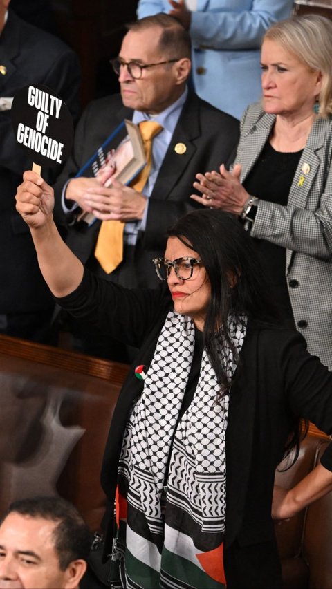 Selain itu, perempuan yang tampil mengenakan Keffiyeh khas Palestina ini juga mengangkat plakat bertuliskan 'Bersalah atas Genosida'. Foto: AFP