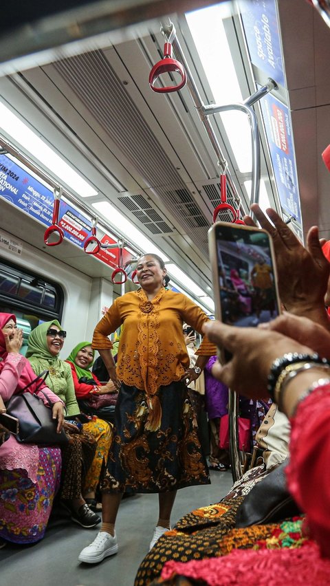 Seseorang sedang mengambil gambar peserta saat bergaya di dalam gerbong LRT. (Liputan6.com/Angga Yuniar)